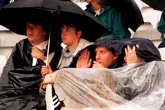 Fans shelter from the pouring rain at the Paul Weller Concert at Don Valley Stadium, Sheffield, in July 1997