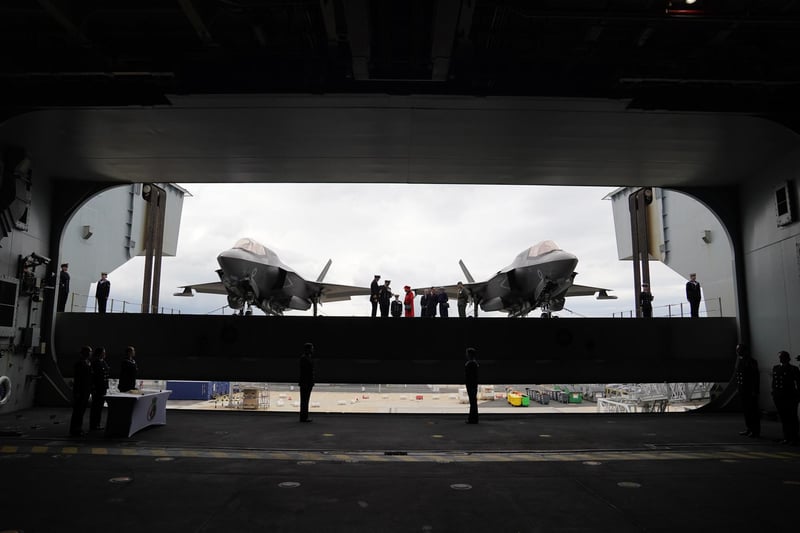 Queen Elizabeth II (centre) going on to the flight deck, with a pair of F-35B Lightning II aircraft on either side, during a visit to HMS Queen Elizabeth at HM Naval Base, Portsmouth, ahead of the ship's maiden deployment. The visit comes as HMS Queen Elizabeth prepares to lead the UK Carrier Strike Group on a 28-week operational deployment travelling over 26,000 nautical miles from the Mediterranean to the Philippine Sea. Picture date: Saturday May 22, 2021. PA Photo. See PA story ROYAL Carrier. Photo credit should read: Steve Parsons/PA Wire