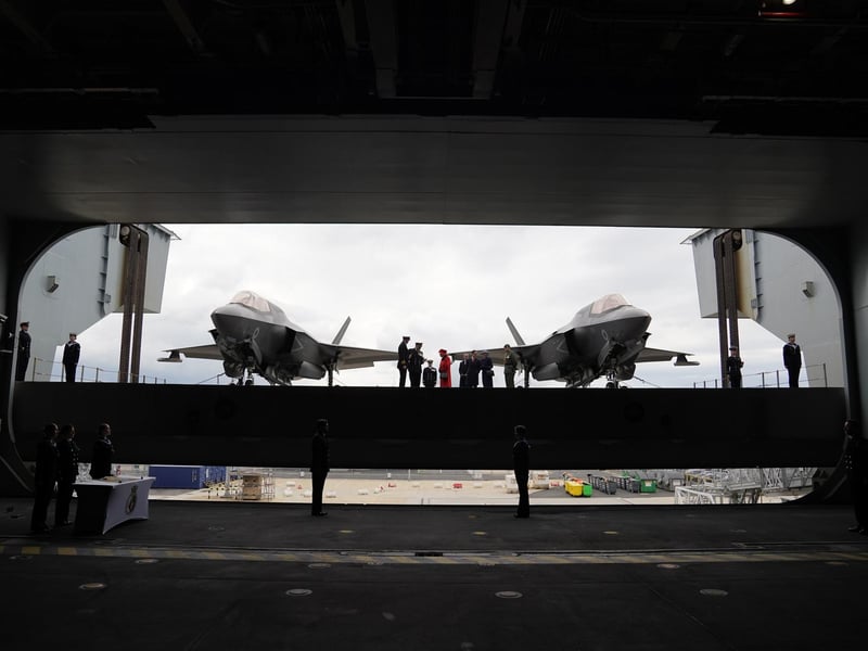 Queen Elizabeth II (centre) going on to the flight deck, with a pair of F-35B Lightning II aircraft on either side, during a visit to HMS Queen Elizabeth at HM Naval Base, Portsmouth, ahead of the ship's maiden deployment. The visit comes as HMS Queen Elizabeth prepares to lead the UK Carrier Strike Group on a 28-week operational deployment travelling over 26,000 nautical miles from the Mediterranean to the Philippine Sea. Picture date: Saturday May 22, 2021. PA Photo. See PA story ROYAL Carrier. Photo credit should read: Steve Parsons/PA Wire