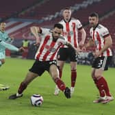 Liverpool's Roberto Firmino, left, scores his side's second goal during the English Premier League soccer match between Sheffield United and Liverpool at Bramall Lane stadium in Sheffield, England, Sunday, Feb. 28, 2021: Lee Smith, Pool via AP