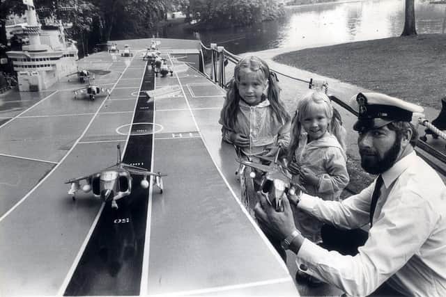 Sheffield Show, 29 August 1980
Petty Officer Harvey Klar from Naval Recruiting shows three year old Katy Watts and her sister Sara aged five from Duncan Road, Crookes, a model of HMS Hermes.