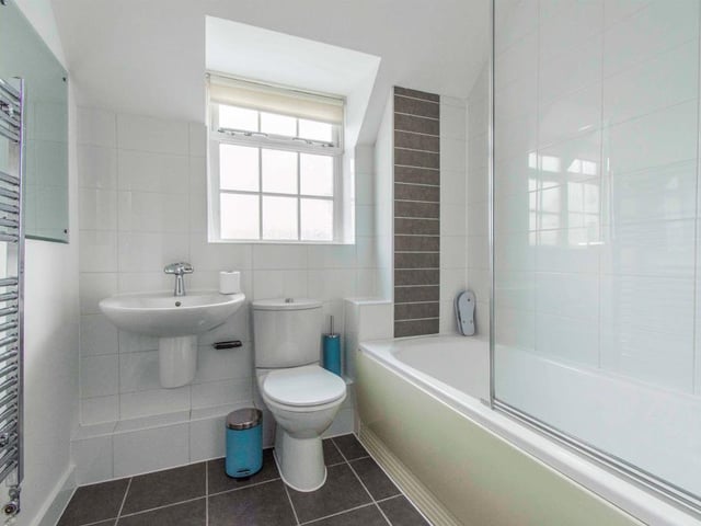 Family Bathroom - Fitted with a WC, a wash hand basin with mixer tap and a bath with shower attachment and screen. There is a heated towel rail, spotlights to the ceiling, partial tiling to the walls and tiled flooring. With a rear facing opaque double glazed window.