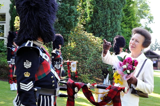 Princess Anne shares a joke with a piper during her 2014 visit to Strathcarron Hospice