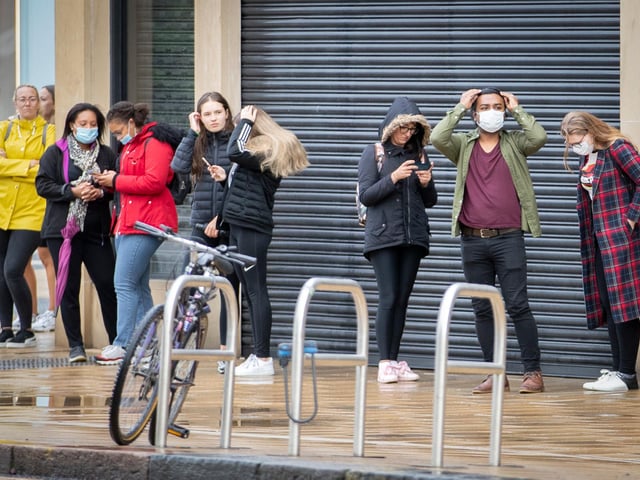Customers queue wearing face masks as advised by the Scottish government.