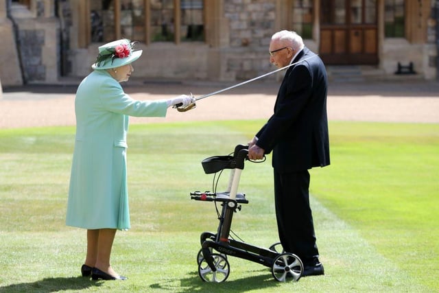 Queen Elizabeth II uses the sword that belonged to her father, George VI as she confers the Honour of Knighthood on Colonel Tom Moore. (Photo by Chris Jackson / POOL / AFP)