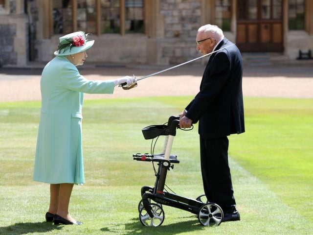 Queen Elizabeth II uses the sword that belonged to her father, George VI as she confers the Honour of Knighthood on Colonel Tom Moore. (Photo by Chris Jackson / POOL / AFP)