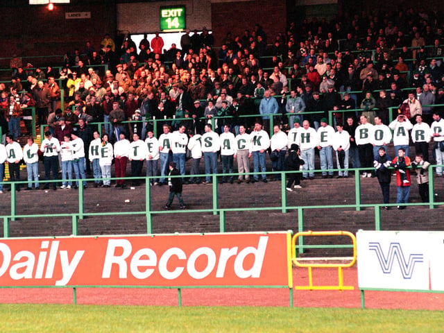 Celtic fans wear t-shirts spelling out the slogan 'Back the team - sack the board' during a home game against Hibs in December 1993