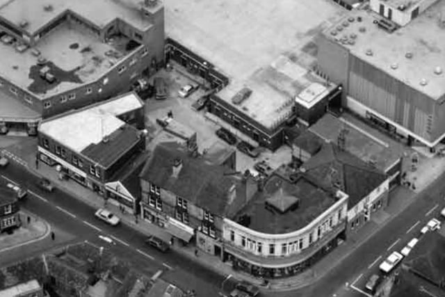 An aerial view showing the junction of Middlewood Road and Bradfield Road in Hillsborough, Sheffield, some time beween 1960 and 1979. The Shakespeare pub, later to become The Shakey, can be seen along with Burton Tailoring and other shops.