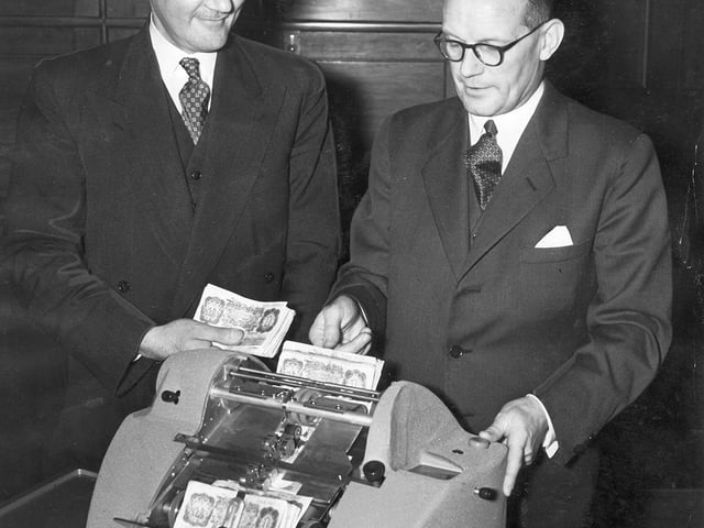 The first banknote counting machine is now at the Midland Bank, High Street, Sheffield, It will count £38,000 in £1 notes per hour. Our picture shows the manager of the branch, Mr F M Crombie (right) demonstrating the machine to his assistant manager Mr J H Hutchinson (left), on January 9, 1953