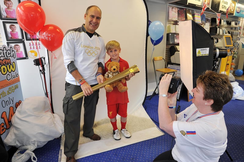 Fundraising day at Max Spielmann for Help for Heroes, Olympic torch bearer Tony Eaton posed for pictures with the torch to raise money for the charity.  Pictured is Tony Eaton with Logan Larkey, nine and shop manager Janet Muxlow.