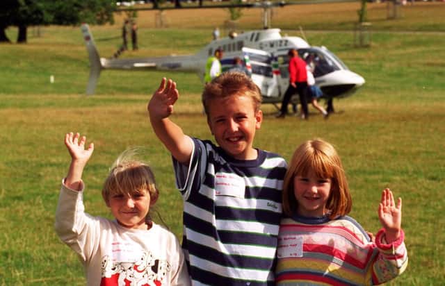 Three youngsters waving at Chatsworth Country Fair in 1996