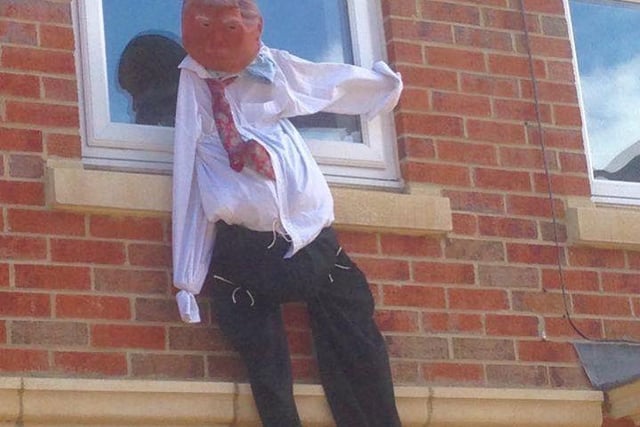 Donald Trump hangs from a window on Brass Thill Way. Created by Shirley Miller.