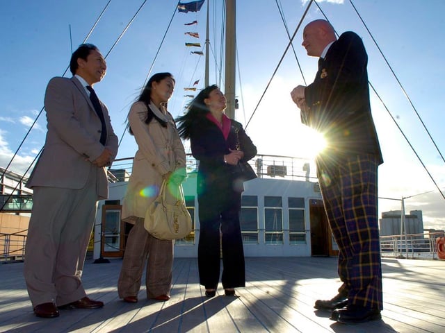 Members of the Royal Family of Bhutan visit the Royal Yacht Britannia. Queen Ashi Dorji Wangmo Wangchuck (pink top) with Princess Sonam Dechen Wangchuck and Prince Jigyel Ugyen Wangchuck. Ted Tombs shows the family around