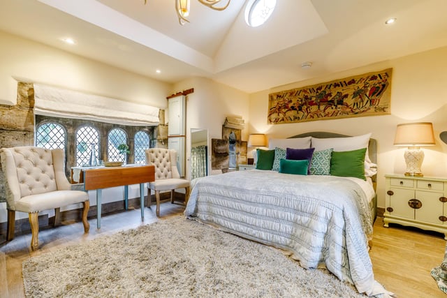 This bedroom has a vaulted ceiling and feature window.