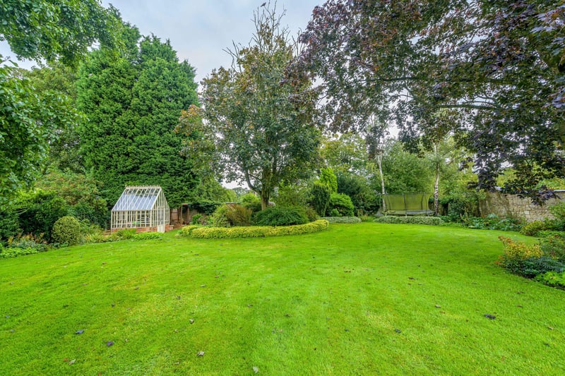 At the rear of the property is a large lawned garden which is partially walled and sits surrounded by mature trees and shrubs.