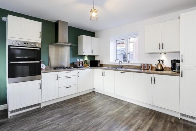 The large entrance hallway takes you to the living room on one side and this modern fitted kitchen on the other. It boasts a range of fitted wall and base units with rolled edge worktops, a stainless steel sink and a half with mixer taps and a drainer, and under-cabinet lighting.