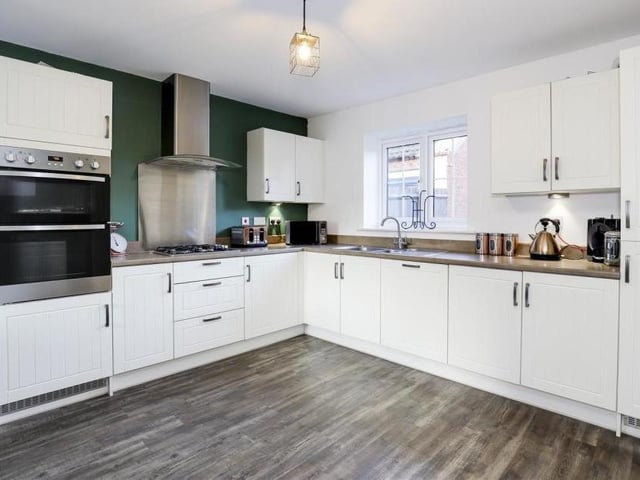 The large entrance hallway takes you to the living room on one side and this modern fitted kitchen on the other. It boasts a range of fitted wall and base units with rolled edge worktops, a stainless steel sink and a half with mixer taps and a drainer, and under-cabinet lighting.