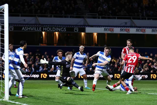 Iliman Ndiaye of Sheffield United (R) scores their team's first goal past Jimmy Dunne and Murphy Mahoney of Queens Park Rangers during the Sky Bet Championship match in west London: Ryan Pierse/Getty Images