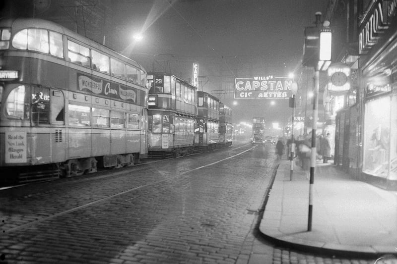 Neon signs light up Argyle Street in the early 1960s as trams head along the street. 