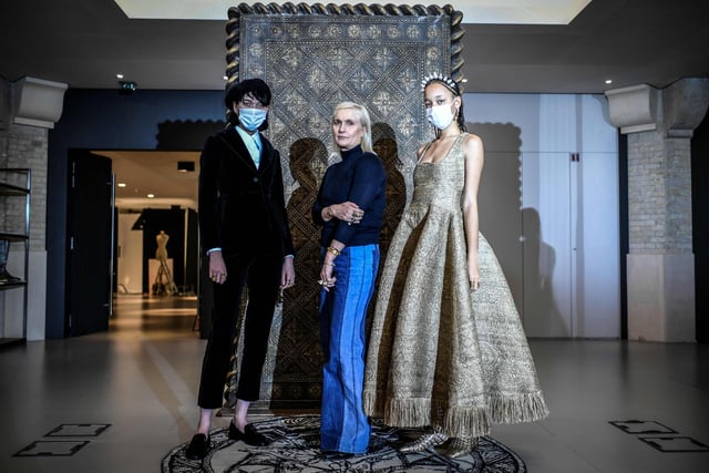 Christian Dior's Italian fashion designer Maria Grazia Chiuri (C) poses with models wearing her creations during a fitting session at Christian Dior's Haute Couture fashion house