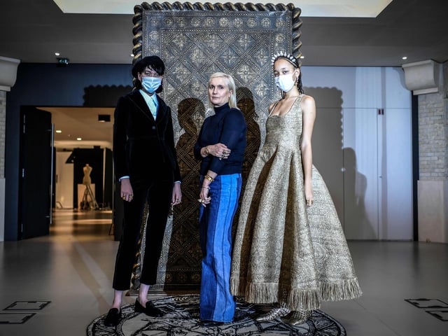 Christian Dior's Italian fashion designer Maria Grazia Chiuri (C) poses with models wearing her creations during a fitting session at Christian Dior's Haute Couture fashion house
