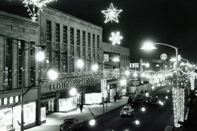 The lights shine brightly over the British Home Stores on The Moor, Sheffield, in December 1962