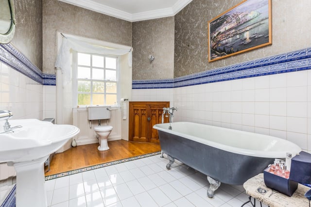 A traditional bathroom suite comprising free standing bath, wash hand basin, W/C and towel rail. Half tiled walls, wooden flooring and storage unit which could be easily covered into a walk in shower unit.