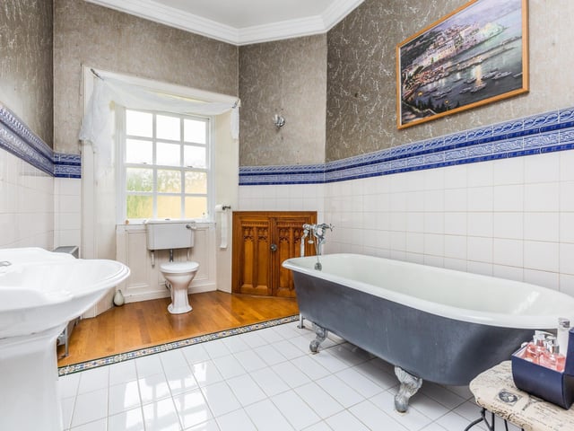 A traditional bathroom suite comprising free standing bath, wash hand basin, W/C and towel rail. Half tiled walls, wooden flooring and storage unit which could be easily covered into a walk in shower unit.