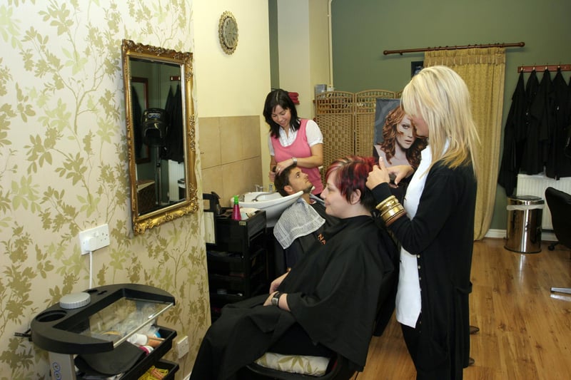 One customer get their hair washed at Morgan hair salon in 2009 while another sits in the chair ready to be worked on
