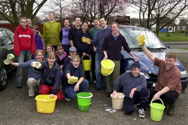 Washing cars to raise money for the their aid project visit to Africa are Lee Potts (front, right), Helen Potts (back row, fifth left), Nicola Belleini (back row, right) and Martin Belleini (back row, second right in 2002