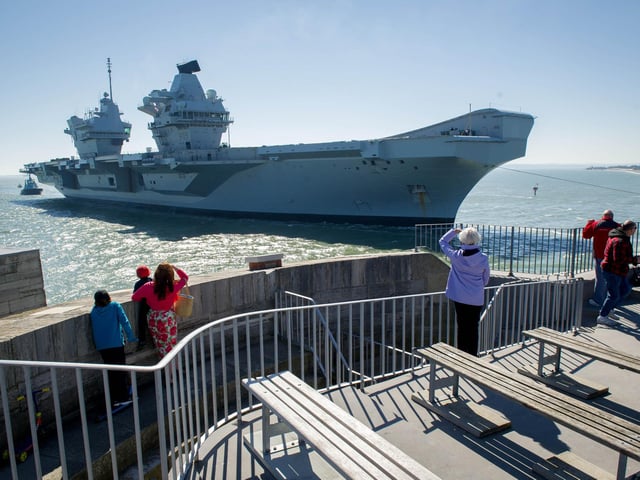 Onlookers watch as HMS Prince of Wales nears the Round Tower.