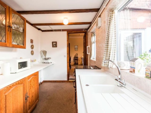 A shot of the kitchen taken from the opposite end of the room. The window brings in lots of natural light.