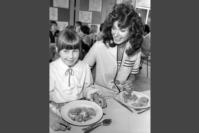 Famous Sheffield comedy star Marti Caine was invited for lunch at Lowedges Junior School, Sheffield,  by  Tina Wild (left) in 1982. This was what school meals looks like in those days, on pastel coloured plates, and just the one option.