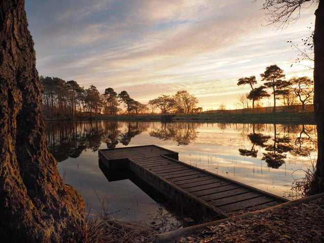 Warm colours of the setting sun at Bowden Moor Loch by Melrose in the Scottish Borders.