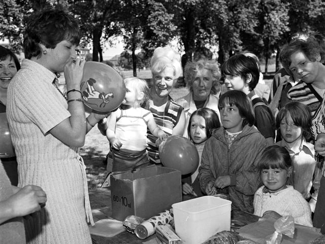 One of the stalls at Leith festival, held on Leith Links in June 1978. A helper blows up balloons as local children look on.