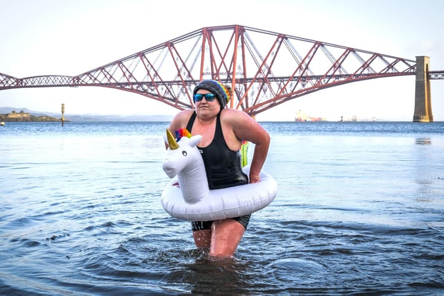 Ashley Park, from Lanark takes part in a New Year's Day dip in front of the Forth Bridge at South Queensferry, Edinburgh. Covid restrictions across Scotland have meant that many new year traditions including the official annual Loony Dook have been cancelled. Picture date: Saturday January 1, 2022. PA Photo. Photo credit: Jane Barlow/PA Wire