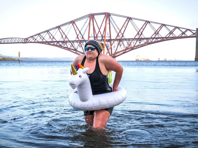 Ashley Park, from Lanark takes part in a New Year's Day dip in front of the Forth Bridge at South Queensferry, Edinburgh. Covid restrictions across Scotland have meant that many new year traditions including the official annual Loony Dook have been cancelled. Picture date: Saturday January 1, 2022. PA Photo. Photo credit: Jane Barlow/PA Wire