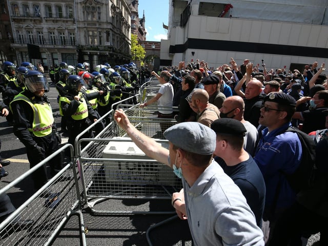 Far-right activists taunt police officers.