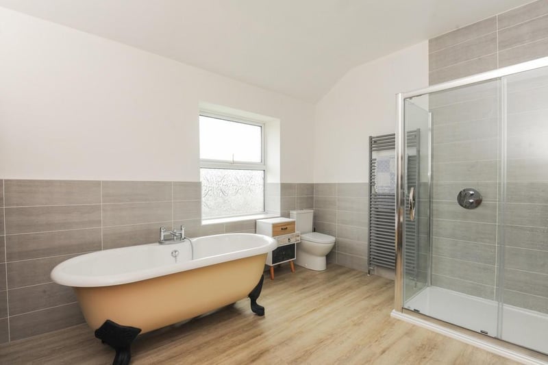 The modern, fitted bathroom boasts a freestanding bath and separate shower.