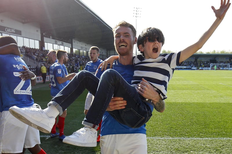 Tom Naylor carries a young fan after Pompey net their winner at Burton in April 2019.