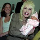 Dolly Parton meets baby Emma Jarman at Rotherham Hospital as her parents Shane and Claire look on. Dolly was in Rotherham to launch a reading scheme.