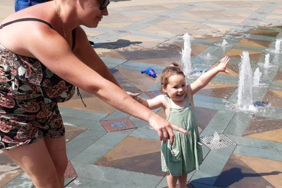 Mum shows her daughter where to look as she cools off in the Peace Gardens