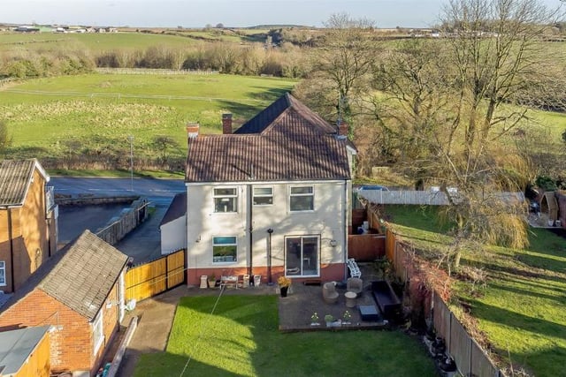 This view from a drone underlines the delightful rural setting of the Buttery Lane property. The countryside spreads far and wide across the road from the front of the house.