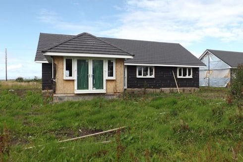 This four bedroom detached bungalow is for sale in Tarbert for offers over £75,000. It is an unfinished new build with stunning views of countryside and out to the Atlantic.
