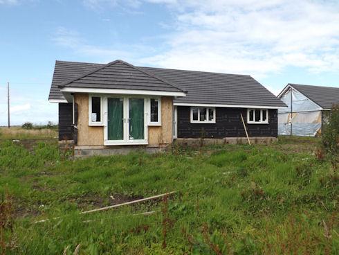 This four bedroom detached bungalow is for sale in Tarbert for offers over £75,000. It is an unfinished new build with stunning views of countryside and out to the Atlantic.