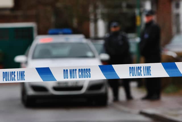 Police tape is pictured as police officers stand guard (Photo by Daniel Berehulak/Getty Images)
