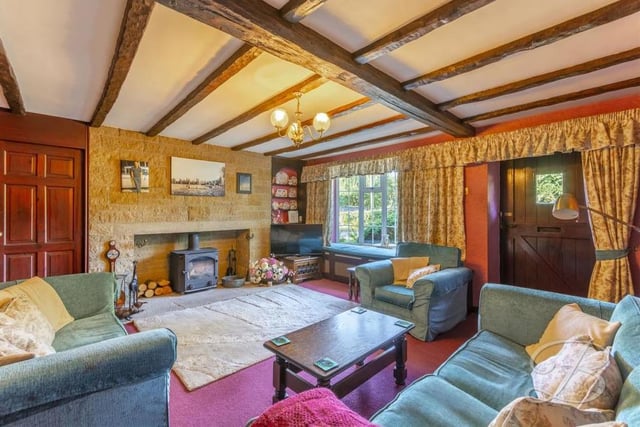 This lovely living room is the hub of the property. Giving a warm, homely feel, it includes exposed beams, a feature fireplace with brick surround, a carpeted floor and a bay window to the front.