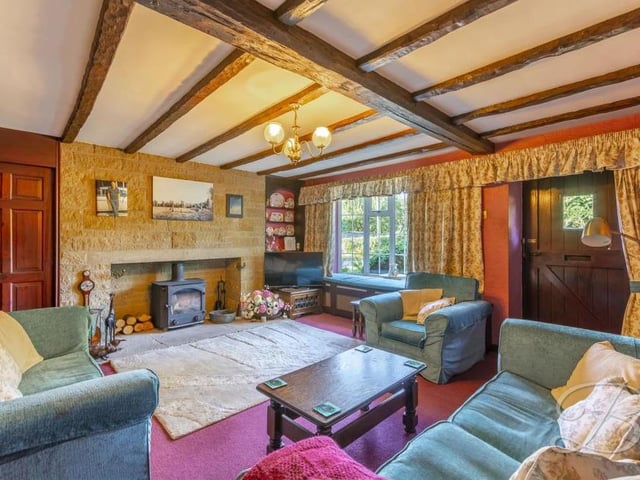 This lovely living room is the hub of the property. Giving a warm, homely feel, it includes exposed beams, a feature fireplace with brick surround, a carpeted floor and a bay window to the front.