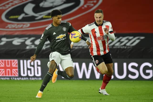 SHEFFIELD, ENGLAND - DECEMBER 17: Marcus Rashford of Manchester United is challenged by Phil Jagielka of Sheffield United during the Premier League match between Sheffield United and Manchester United at Bramall Lane on December 17, 2020 in Sheffield, England.  (Photo by Rui Vieira - Pool/Getty Images)