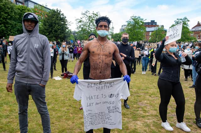 A demonstrator with 'George Floyd RIP' written on his chest